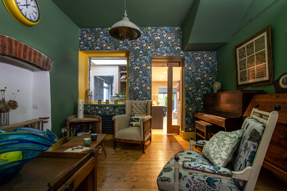 На фото: гостиная комната среднего размера в стиле кантри с зелеными стенами и обоями на стенах с