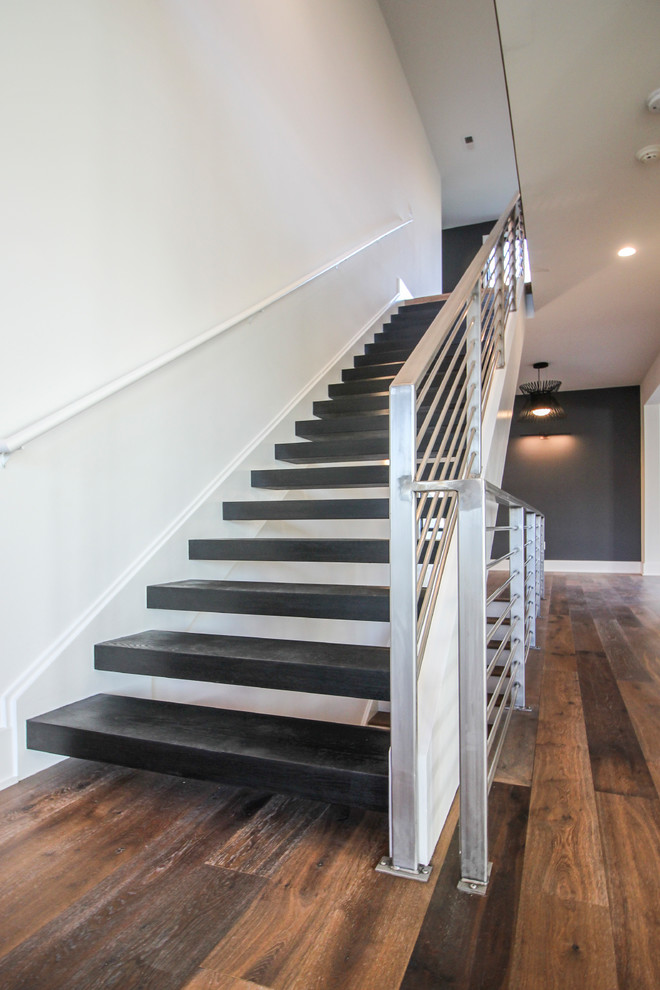 This is an example of a large contemporary wood floating staircase in DC Metro with metal railing.