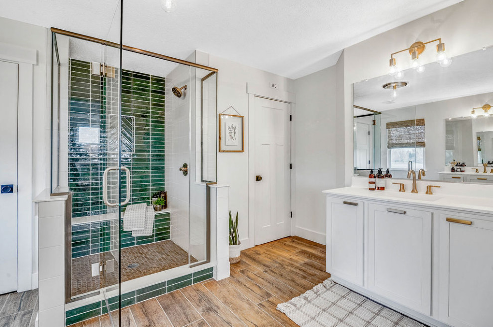 Photo of a country bathroom in Columbus with shaker cabinets, white cabinets, green tile, ceramic tile, white walls, ceramic floors, solid surface benchtops, brown floor, a hinged shower door, white benchtops and a single vanity.