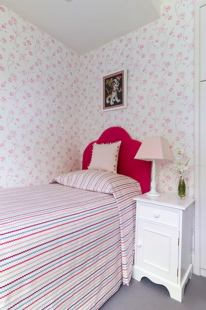 This is an example of a mid-sized modern kids' bedroom for kids 4-10 years old and girls in London with pink walls.