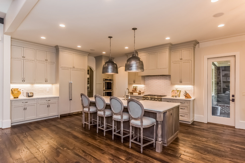Open concept kitchen - large transitional l-shaped dark wood floor open concept kitchen idea in Atlanta with shaker cabinets, gray cabinets, marble countertops, white backsplash, stone tile backsplash, stainless steel appliances, an island and a farmhouse sink