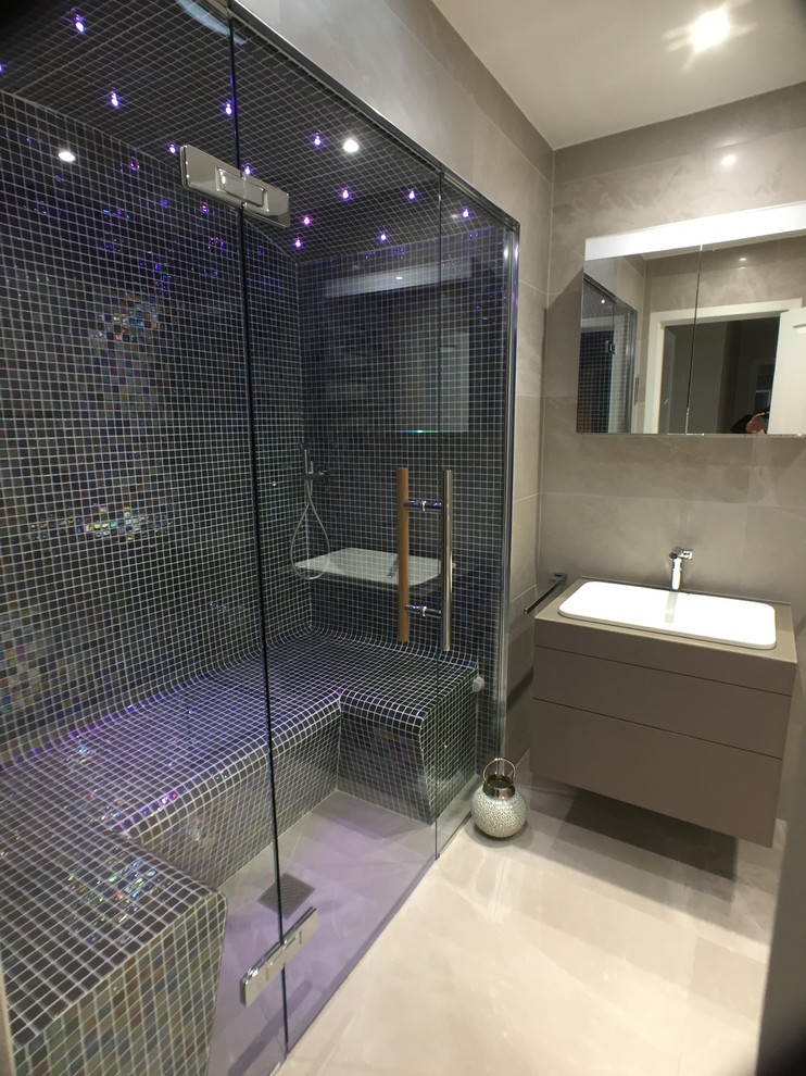 This is an example of a contemporary bathroom in Edinburgh with flat-panel cabinets, brown cabinets, multi-coloured tile, mosaic tile, porcelain floors, with a sauna, an integrated sink and grey floor.