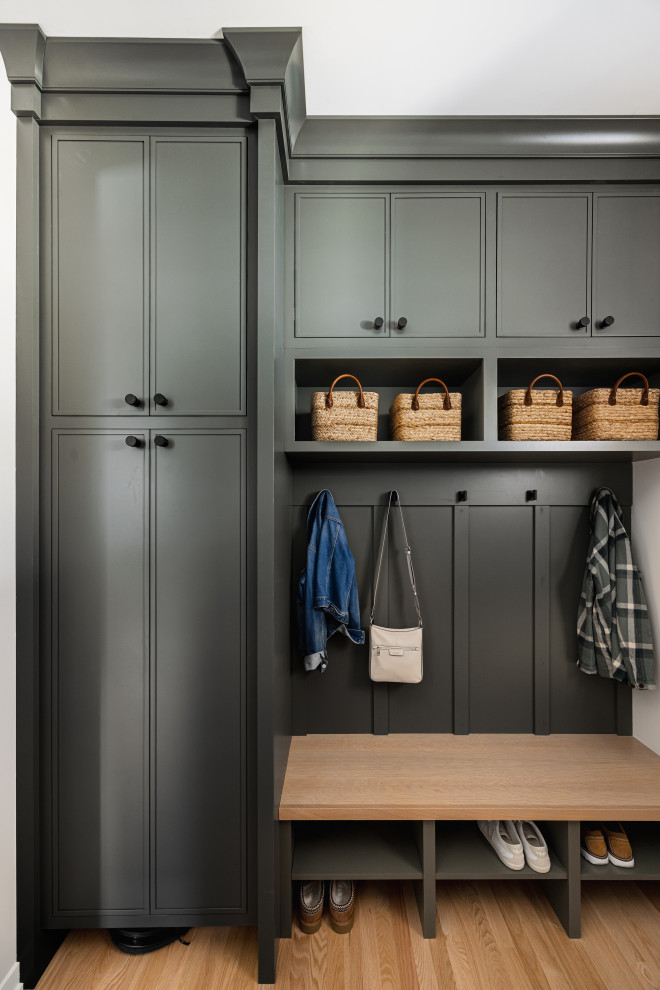 Inspiration for a mid-sized cottage galley light wood floor and brown floor utility room remodel in Minneapolis with an undermount sink, shaker cabinets, green cabinets, quartz countertops, white backsplash, white walls, a side-by-side washer/dryer and gray countertops