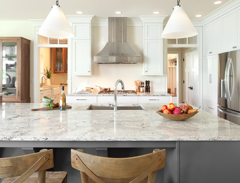 Inspiration for a large transitional l-shaped eat-in kitchen in Orlando with a farmhouse sink, recessed-panel cabinets, white cabinets, marble benchtops, white splashback, porcelain splashback, stainless steel appliances and with island.