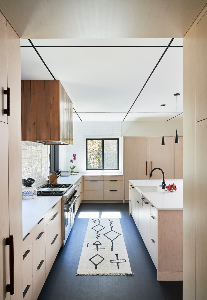 Eat-in kitchen - large rustic u-shaped dark wood floor and beige floor eat-in kitchen idea with flat-panel cabinets, light wood cabinets, quartzite countertops, white backsplash, ceramic backsplash, stainless steel appliances, an island and white countertops