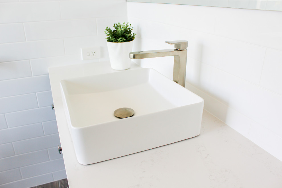 Large modern master bathroom in Perth with shaker cabinets, blue cabinets, a freestanding tub, a curbless shower, white tile, ceramic tile, multi-coloured walls, wood-look tile, a vessel sink, engineered quartz benchtops, multi-coloured floor, a hinged shower door and white benchtops.