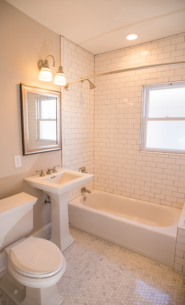 This is an example of a small traditional master bathroom in Milwaukee with a drop-in tub, an open shower, a two-piece toilet, white tile, subway tile, grey walls, marble floors and a pedestal sink.