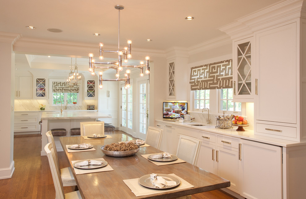 Example of a large transitional u-shaped medium tone wood floor eat-in kitchen design in New York with white cabinets, stone slab backsplash, paneled appliances, an island, an undermount sink, recessed-panel cabinets and marble countertops