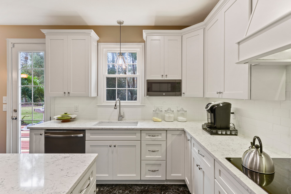 Inspiration for a mid-sized modern u-shaped eat-in kitchen in Jacksonville with a farmhouse sink, shaker cabinets, white cabinets, quartzite benchtops, white splashback, subway tile splashback, coloured appliances, porcelain floors, with island and black floor.