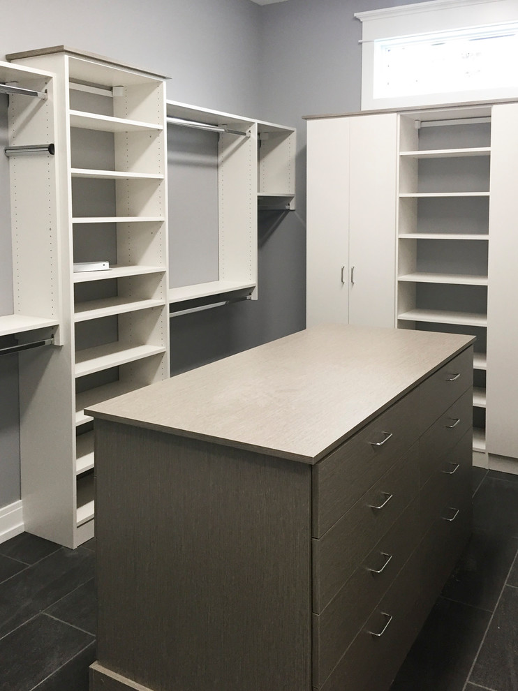 Inspiration for a large contemporary gender-neutral walk-in wardrobe in Other with flat-panel cabinets, grey cabinets and grey floor.