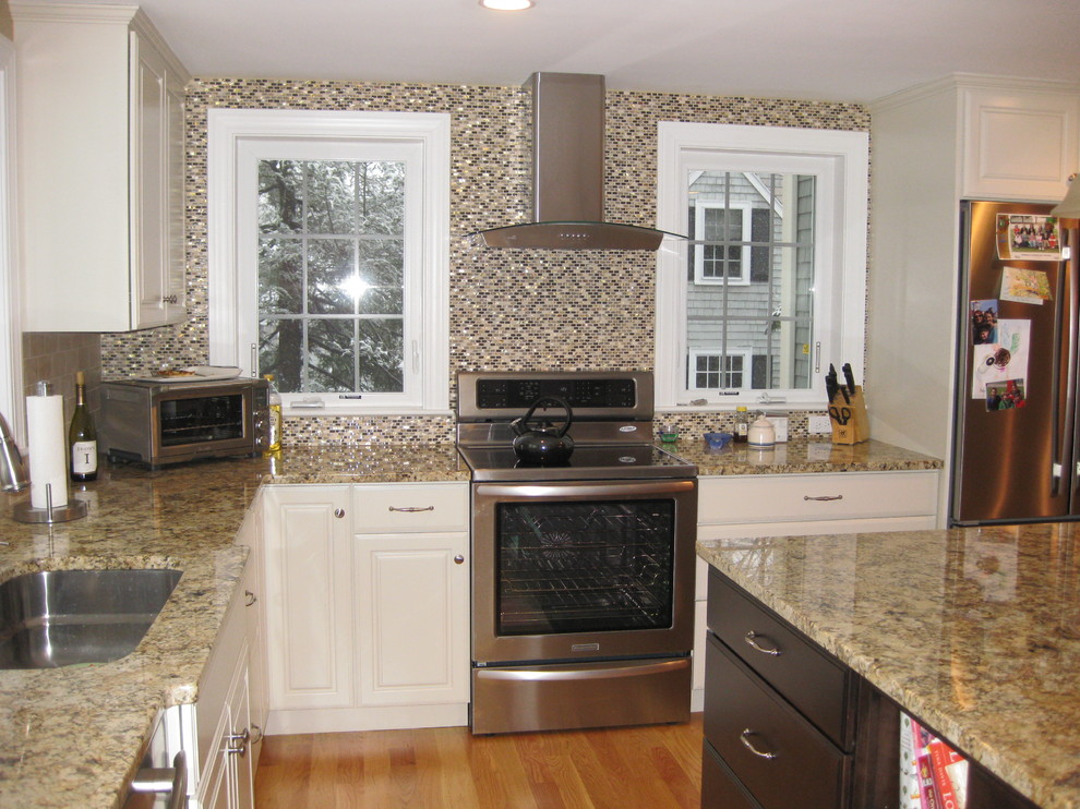 Eat-in kitchen - transitional l-shaped light wood floor eat-in kitchen idea in Boston with an undermount sink, raised-panel cabinets, white cabinets, granite countertops, beige backsplash, stainless steel appliances, an island and ceramic backsplash
