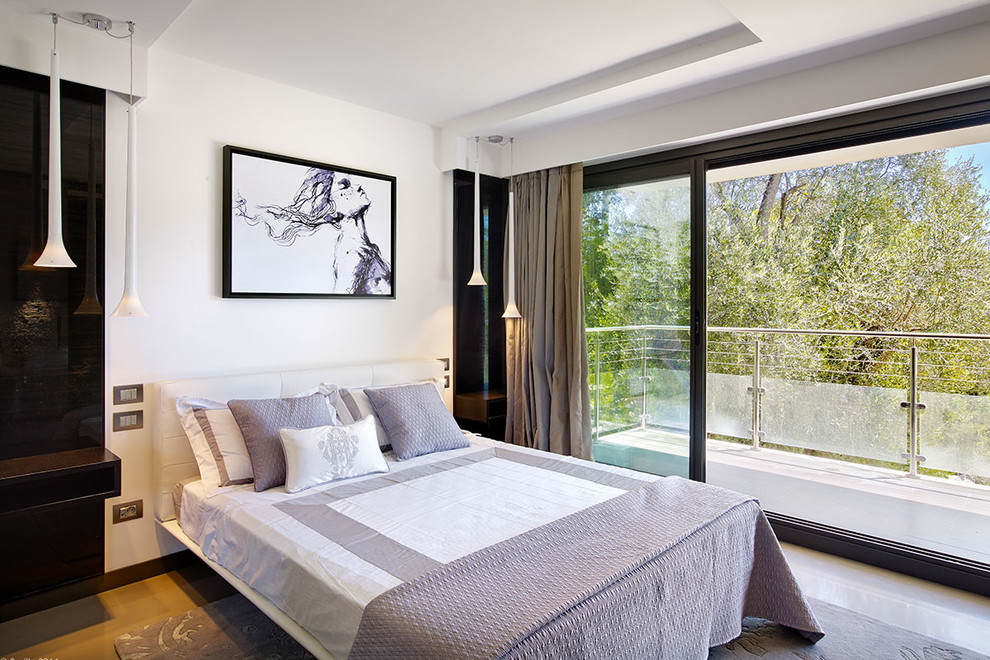 This is an example of a contemporary bedroom in Nice with white walls and medium hardwood floors.