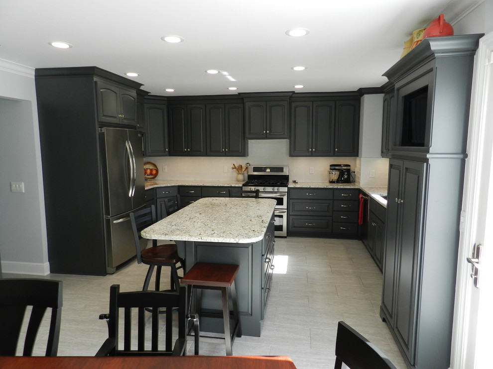 Enclosed kitchen - mid-sized transitional l-shaped porcelain tile and beige floor enclosed kitchen idea in Cleveland with an undermount sink, raised-panel cabinets, gray cabinets, granite countertops, white backsplash, subway tile backsplash, stainless steel appliances and an island