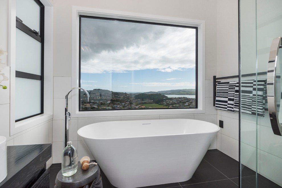 Design ideas for a large contemporary bathroom in Wellington with black cabinets, a freestanding tub, a double shower, black and white tile, stone tile, white walls and a vessel sink.