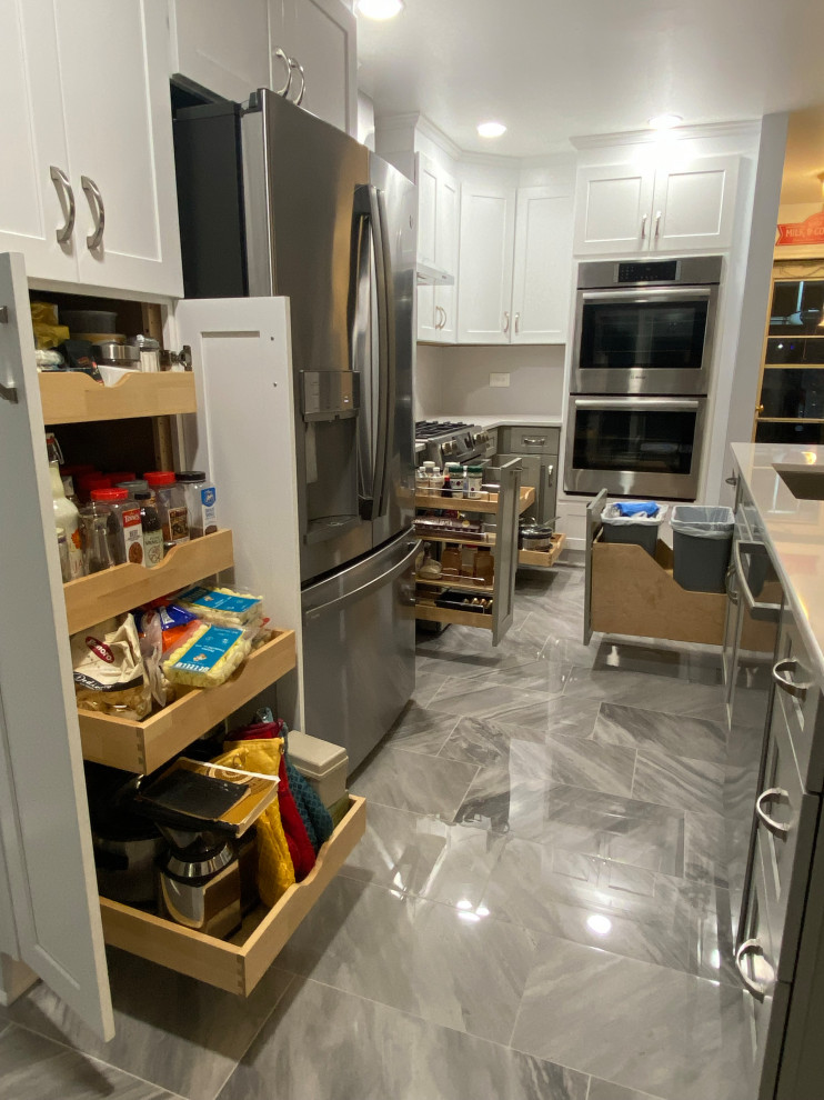 This is an example of a mid-sized transitional l-shaped eat-in kitchen in Chicago with shaker cabinets, quartz benchtops and with island.