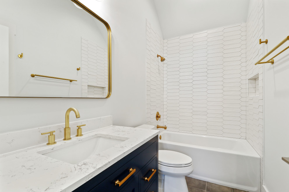 На фото: главная ванная комната среднего размера в морском стиле с плоскими фасадами, синими фасадами, ванной в нише, душем в нише, раздельным унитазом, белой плиткой, керамогранитной плиткой, серыми стенами, полом из керамогранита, врезной раковиной, мраморной столешницей, серым полом, шторкой для ванной, белой столешницей, нишей, тумбой под одну раковину и напольной тумбой
