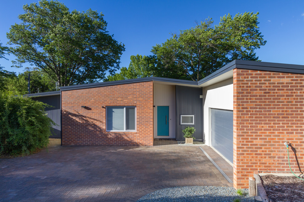 Design ideas for a mid-sized contemporary one-storey brick house exterior in Canberra - Queanbeyan with a metal roof.