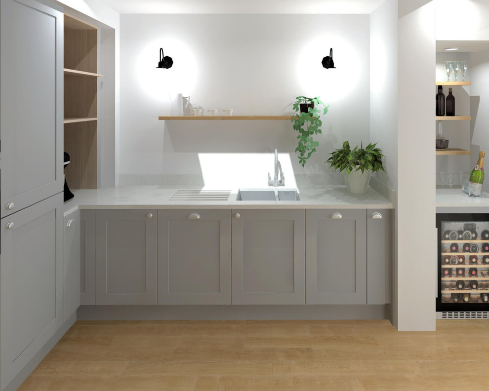 Inredning av ett klassiskt stort vit vitt kök, med en dubbel diskho, skåp i shakerstil, grå skåp, bänkskiva i kvartsit, vitt stänkskydd, svarta vitvaror, ljust trägolv, en köksö och brunt golv