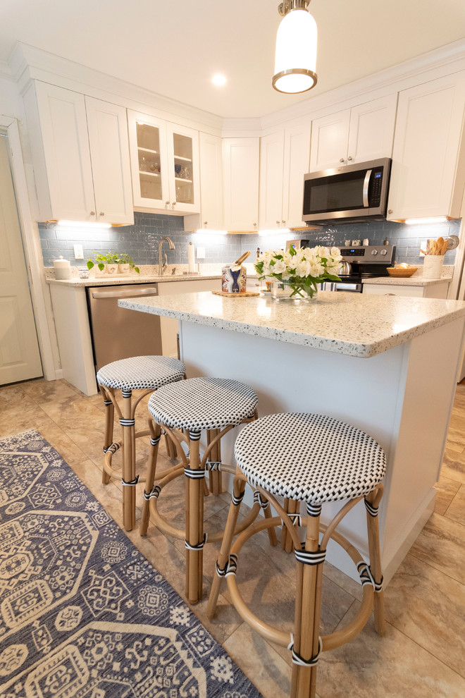 Example of a mid-sized transitional u-shaped beige floor enclosed kitchen design in Boston with an undermount sink, recessed-panel cabinets, white cabinets, blue backsplash, subway tile backsplash, stainless steel appliances, an island and beige countertops