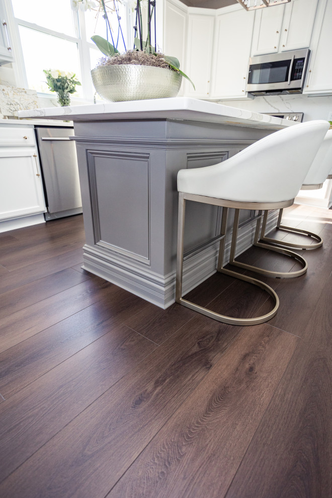 Example of a large classic l-shaped vinyl floor and brown floor eat-in kitchen design in Columbus with a drop-in sink, shaker cabinets, white cabinets, granite countertops, white backsplash, granite backsplash, stainless steel appliances, an island and white countertops