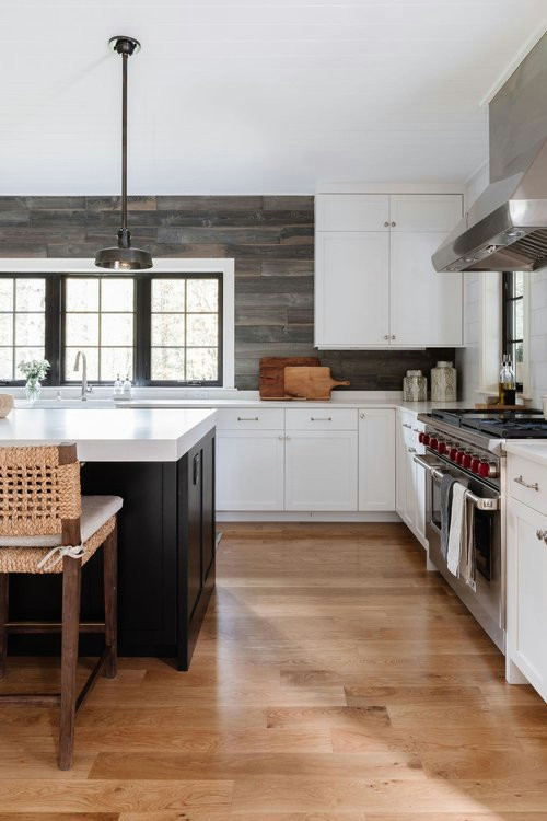 Foto di una cucina minimal chiusa e di medie dimensioni con lavello sottopiano, ante in stile shaker, ante bianche, elettrodomestici da incasso e pavimento in legno massello medio