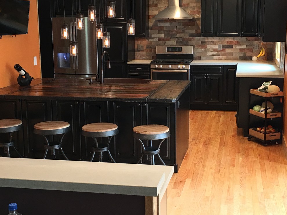 Mountain style kitchen photo in New York with concrete countertops and brick backsplash