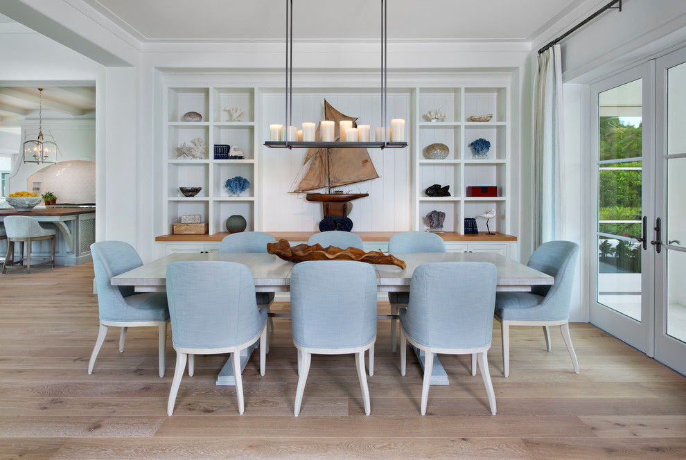 Design ideas for a beach style dining room in Miami with white walls, light hardwood floors, no fireplace and beige floor.