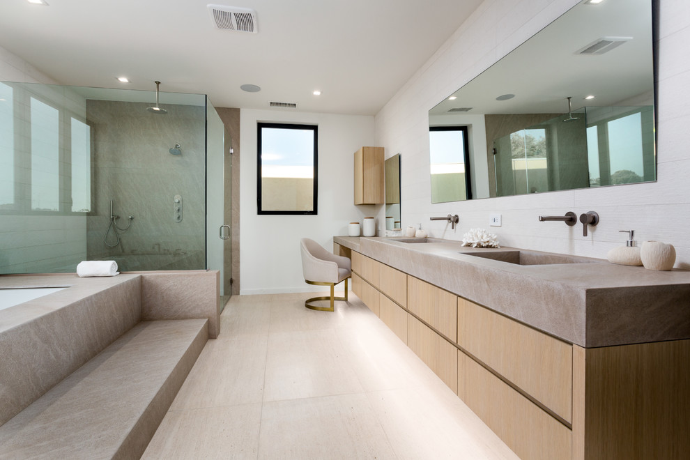 Design ideas for a large contemporary master bathroom in Los Angeles with flat-panel cabinets, light wood cabinets, an undermount tub, a curbless shower, white walls, an integrated sink, concrete benchtops, beige floor, a hinged shower door and grey benchtops.
