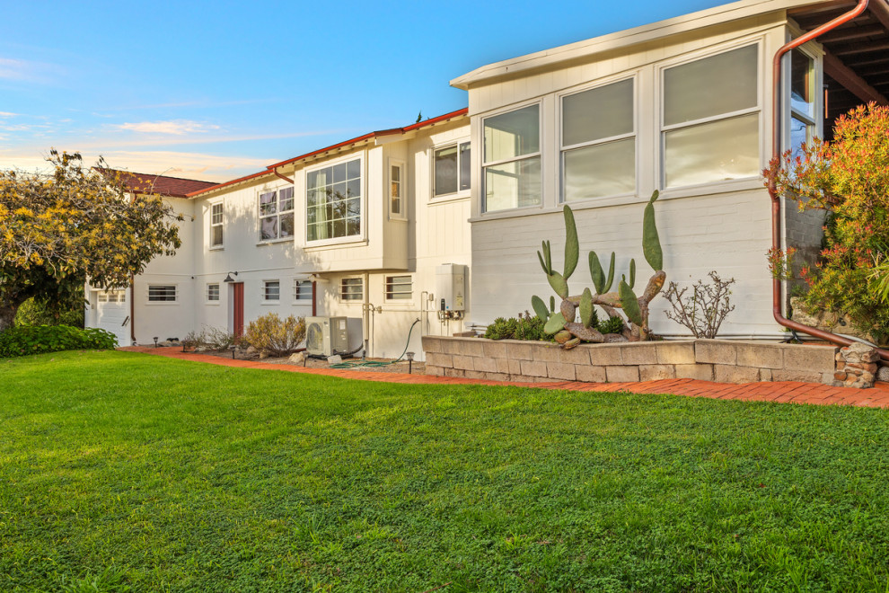 This is an example of an expansive and white classic bungalow detached house in San Diego with wood cladding, a hip roof, a shingle roof, a red roof and board and batten cladding.