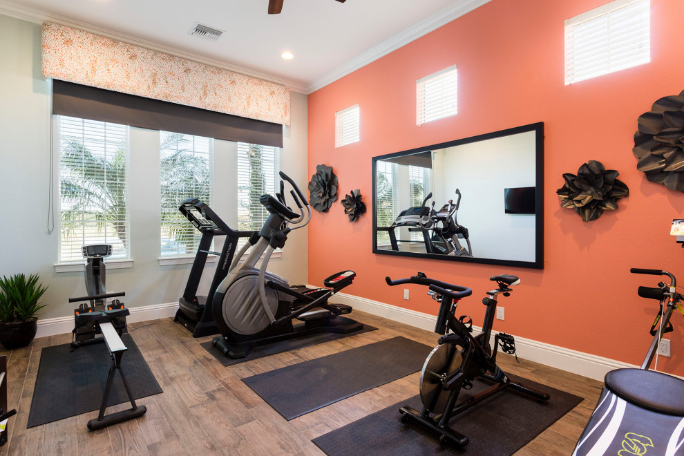 This is an example of a mid-sized transitional multipurpose gym in Orlando with orange walls, porcelain floors and brown floor.