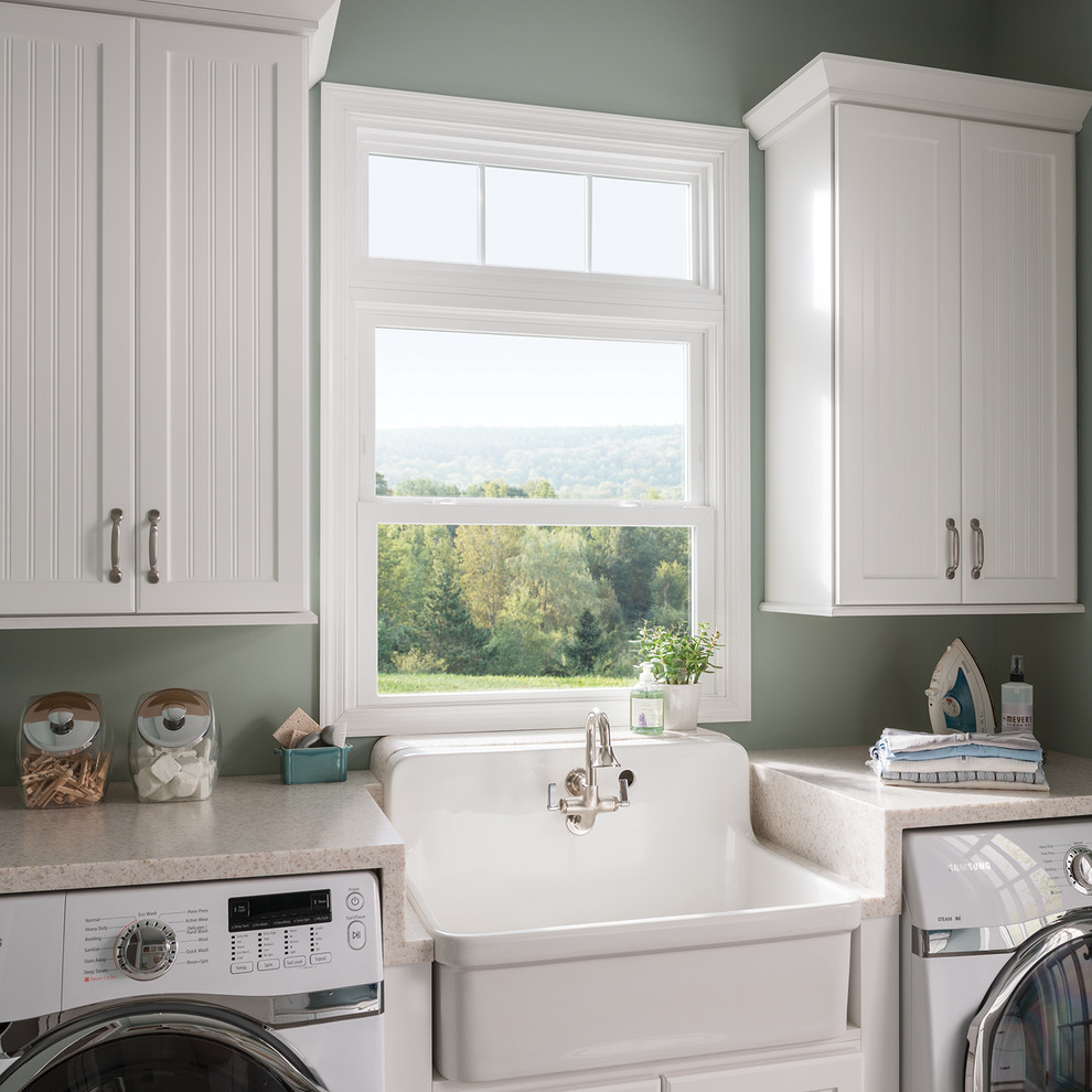 Design ideas for a country single-wall laundry room in Santa Barbara with an utility sink, recessed-panel cabinets, white cabinets, quartz benchtops, green walls, a side-by-side washer and dryer and beige benchtop.