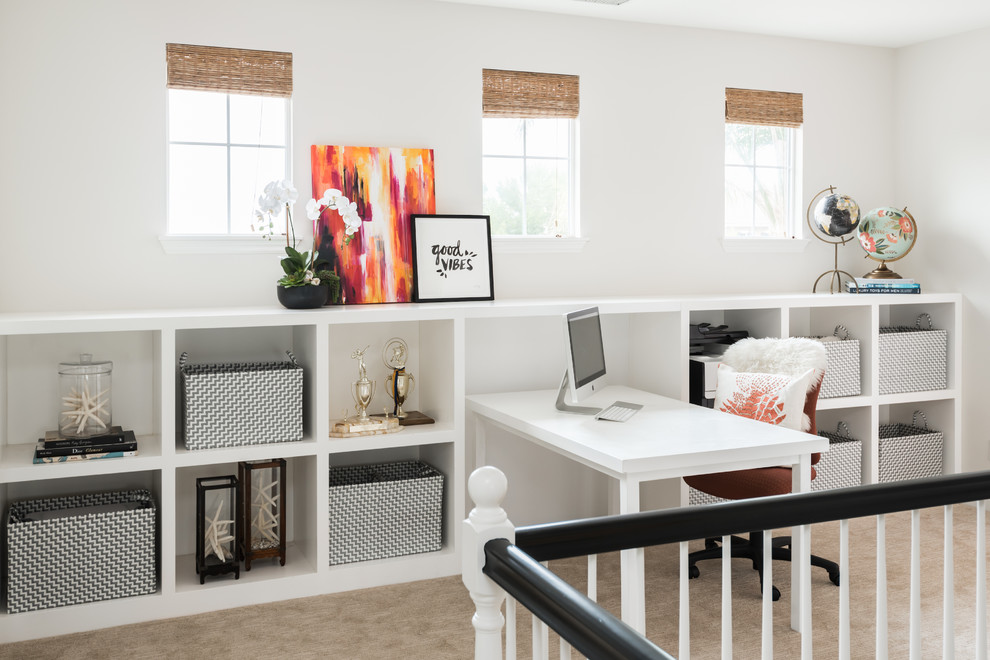This is an example of a small beach style study room in Orange County with white walls, no fireplace, a built-in desk and beige floor.