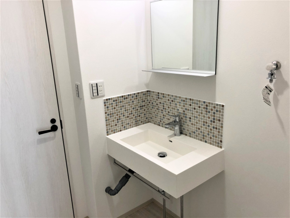 This is an example of an industrial powder room in Other with open cabinets, white cabinets, brown tile, mosaic tile, white walls, vinyl floors, a wall-mount sink, solid surface benchtops, grey floor, white benchtops, a floating vanity, wallpaper and wallpaper.