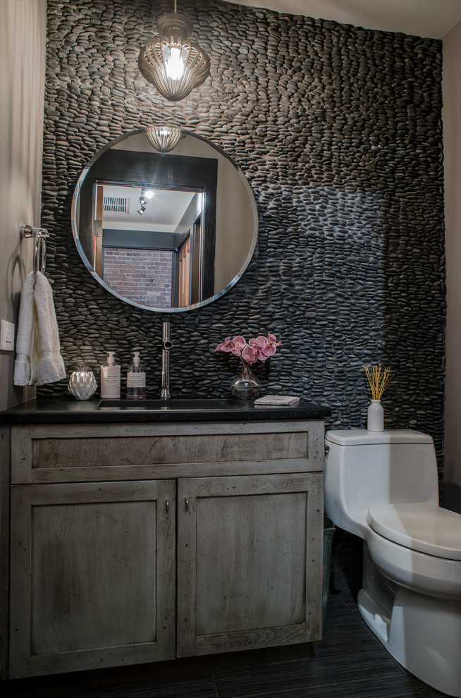 Small industrial powder room in Philadelphia with shaker cabinets, distressed cabinets, a one-piece toilet, pebble tile, a drop-in sink, engineered quartz benchtops and grey floor.