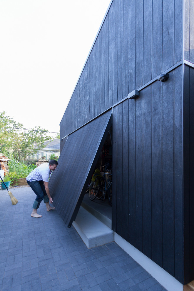 На фото: маленький, одноэтажный, деревянный, черный дом в современном стиле для на участке и в саду с