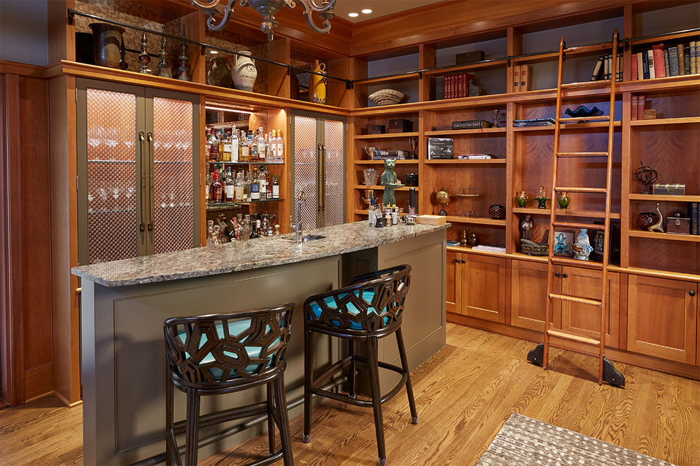 Design ideas for a mid-sized traditional u-shaped seated home bar in Seattle with an undermount sink, open cabinets, brown cabinets, granite benchtops, medium hardwood floors, brown floor and multi-coloured benchtop.