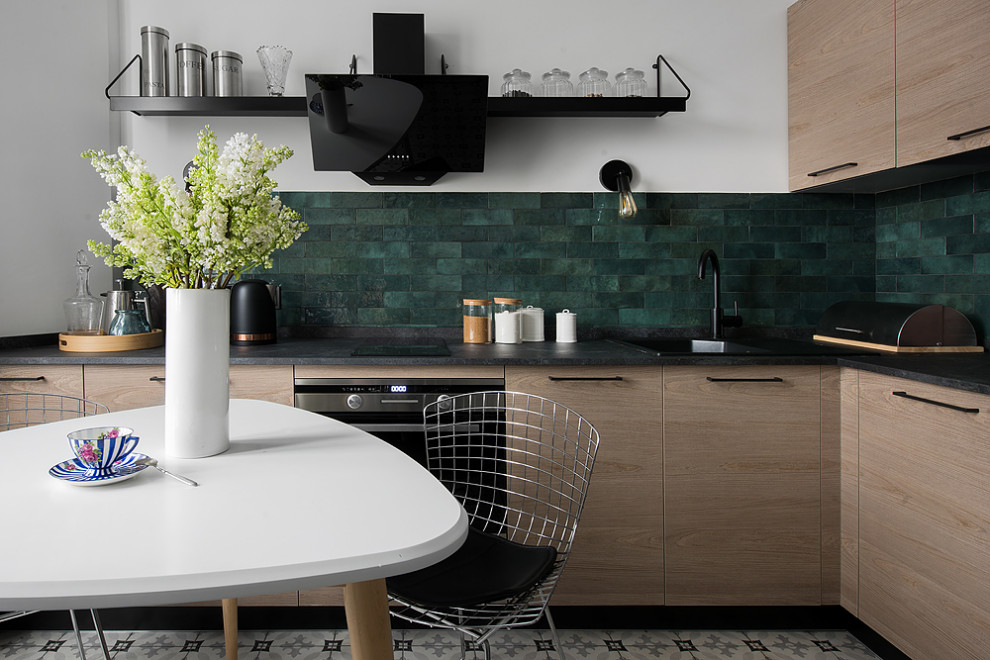 Mid-sized trendy l-shaped porcelain tile and multicolored floor eat-in kitchen photo in Moscow with a single-bowl sink, flat-panel cabinets, medium tone wood cabinets, quartz countertops, green backsplash, ceramic backsplash, black appliances and black countertops