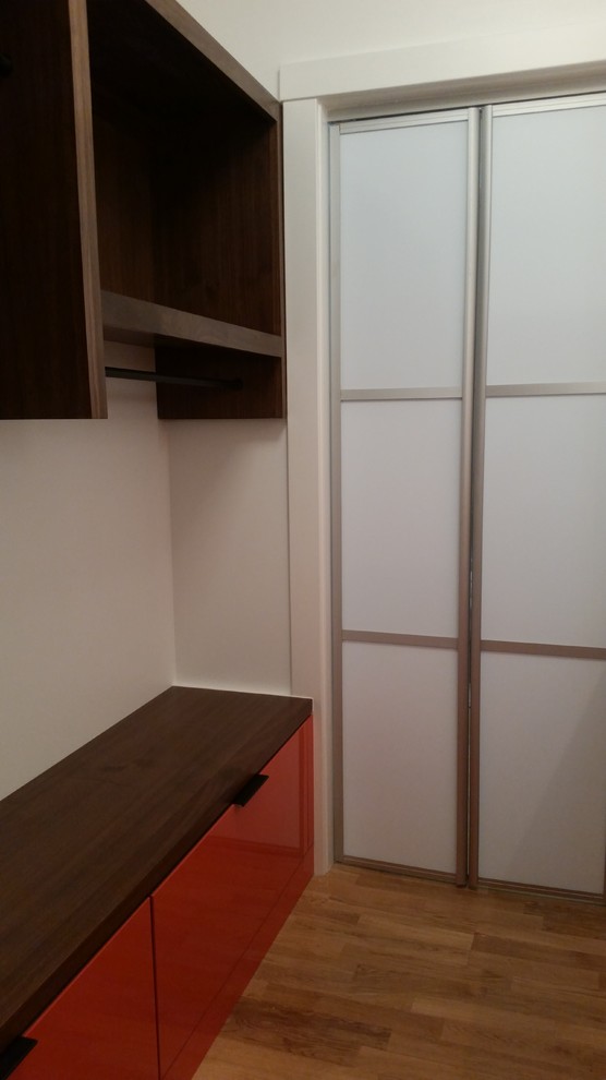 Cette photo montre un dressing et rangement moderne de taille moyenne avec un placard à porte plane et des portes de placard oranges.