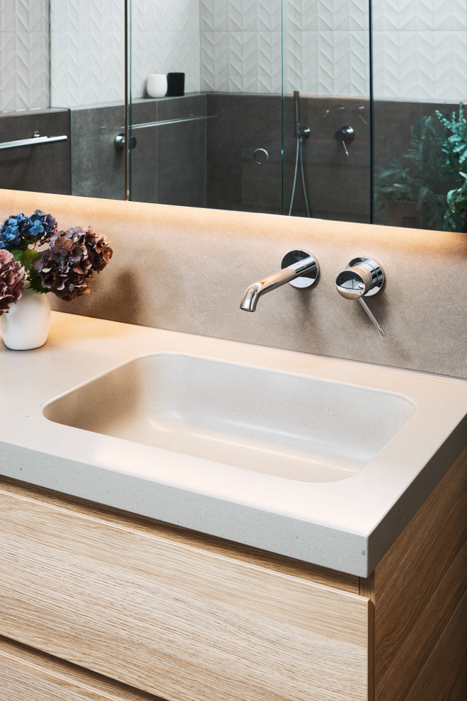 Inspiration for a mid-sized contemporary master bathroom in Melbourne with light wood cabinets, an undermount tub, a corner shower, a wall-mount toilet, ceramic tile, porcelain floors, solid surface benchtops, grey floor, a hinged shower door, grey benchtops, a shower seat, white tile, white walls, an undermount sink, a single vanity and a floating vanity.