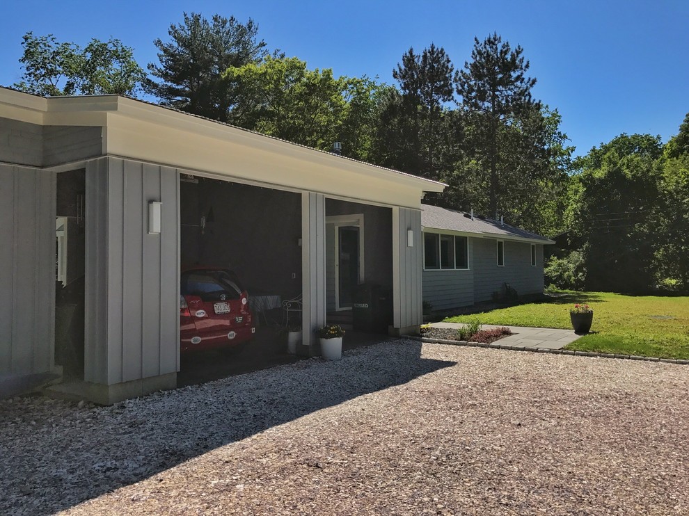 This is an example of a mid-sized midcentury one-storey grey house exterior in Boston with mixed siding and a shed roof.