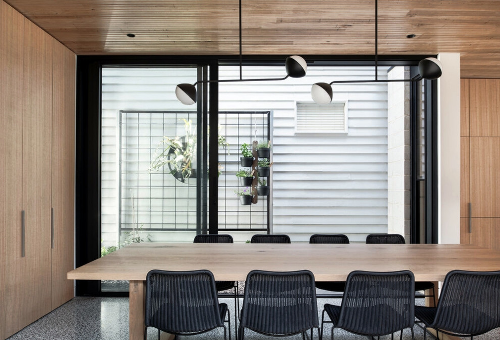 Immagine di una sala da pranzo aperta verso il soggiorno nordica di medie dimensioni con pavimento in cemento