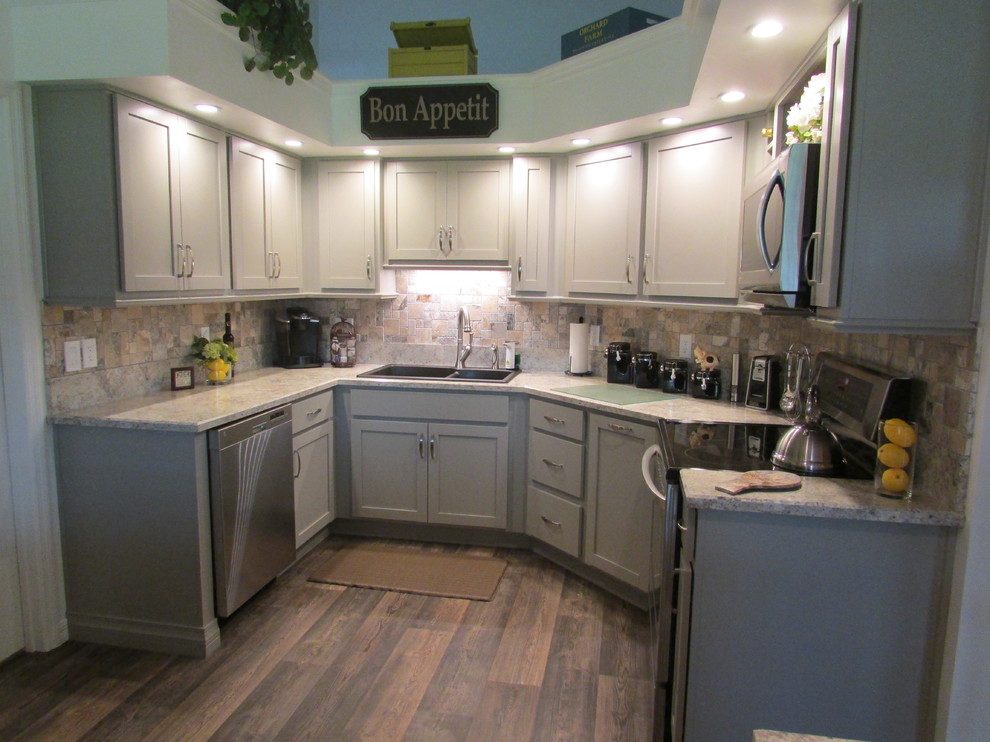 Photo of a mid-sized transitional separate kitchen in Orlando with a double-bowl sink, shaker cabinets, grey cabinets, laminate benchtops, brown splashback, stone tile splashback, stainless steel appliances, vinyl floors and no island.