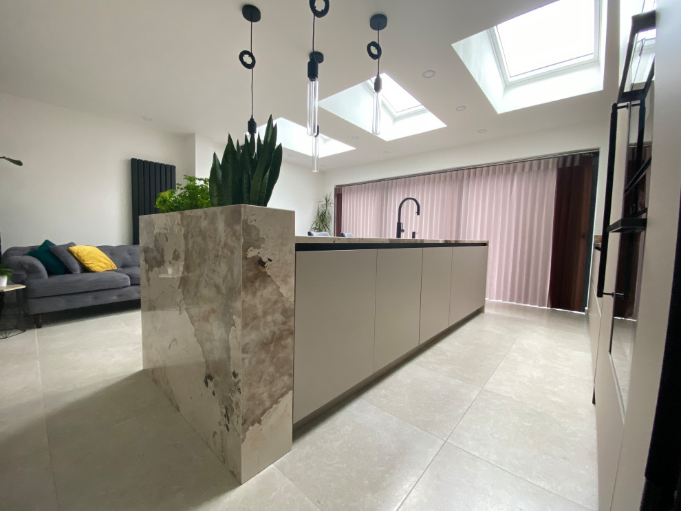 Design ideas for a medium sized contemporary grey and brown galley open plan kitchen in Manchester with a submerged sink, flat-panel cabinets, beige cabinets, engineered stone countertops, multi-coloured splashback, stone slab splashback, coloured appliances, porcelain flooring, an island, beige floors and multicoloured worktops.