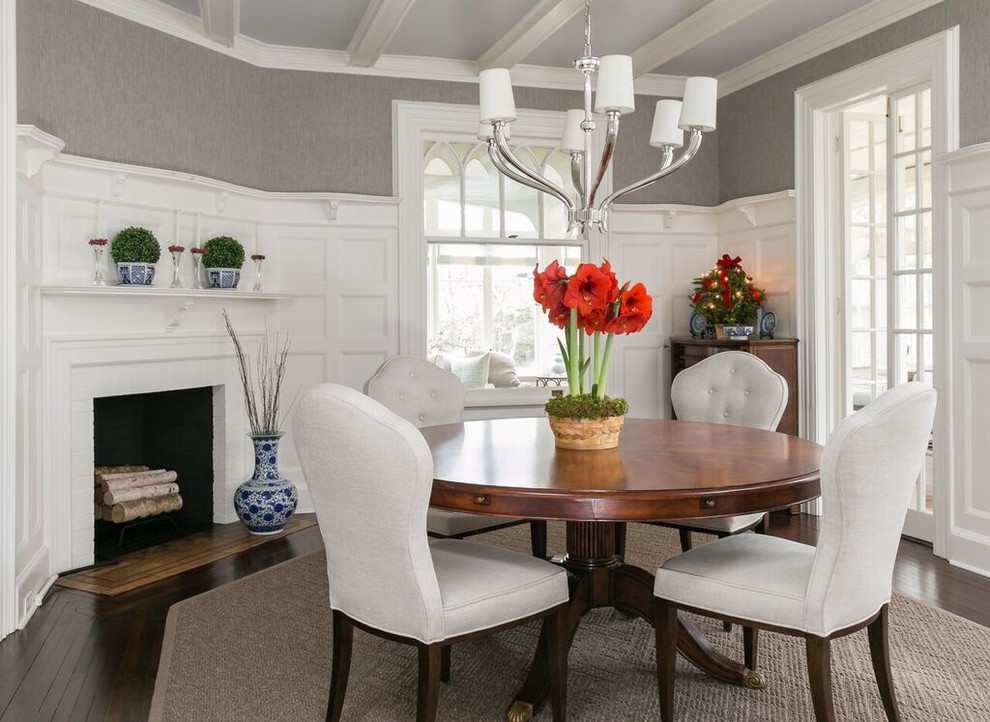 Transitional separate dining room in New York with grey walls, dark hardwood floors and a corner fireplace.