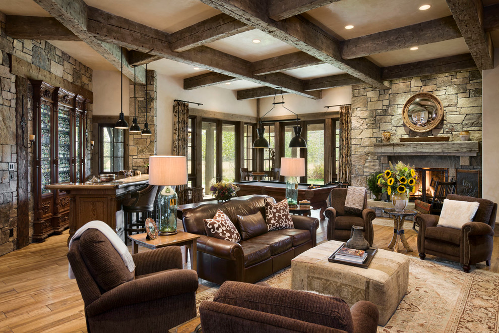 Inspiration for a country open concept family room in Other with beige walls, medium hardwood floors, a standard fireplace and a stone fireplace surround.