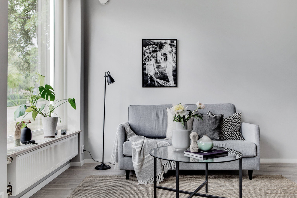 Design ideas for a small scandinavian formal enclosed living room in Stockholm with grey walls, laminate floors and grey floor.