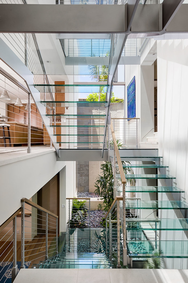 Photo of a large contemporary glass staircase in Los Angeles with open risers.