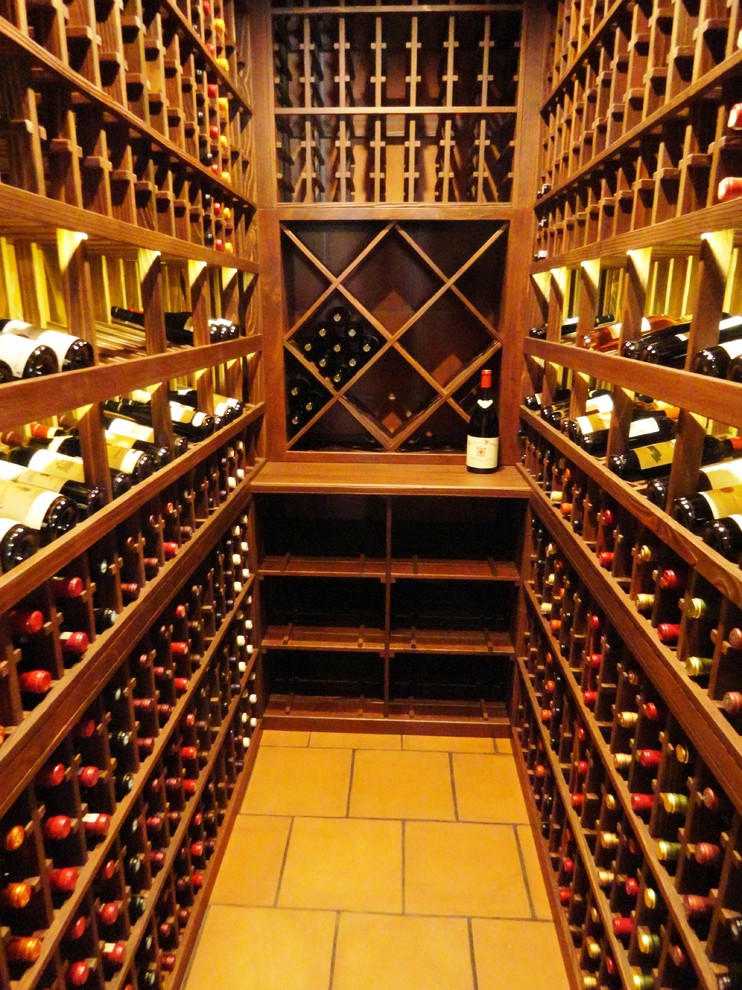 This is an example of a small traditional wine cellar in San Diego with ceramic floors, display racks and yellow floor.