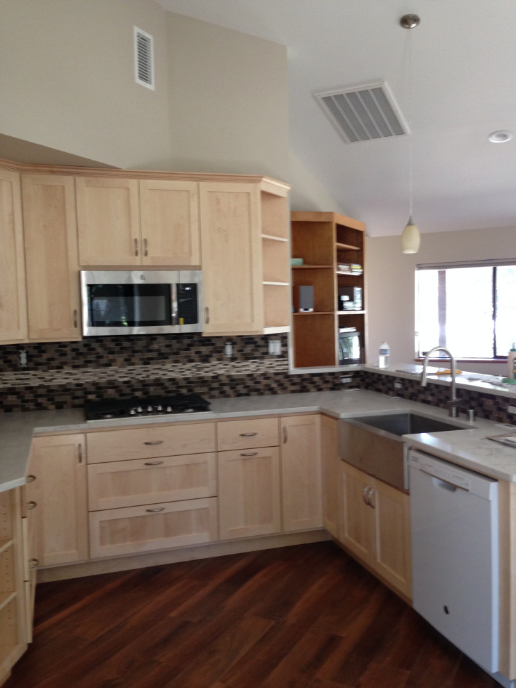 Kitchen - large kitchen idea with a farmhouse sink, shaker cabinets, light wood cabinets, quartz countertops, multicolored backsplash, glass tile backsplash and white countertops