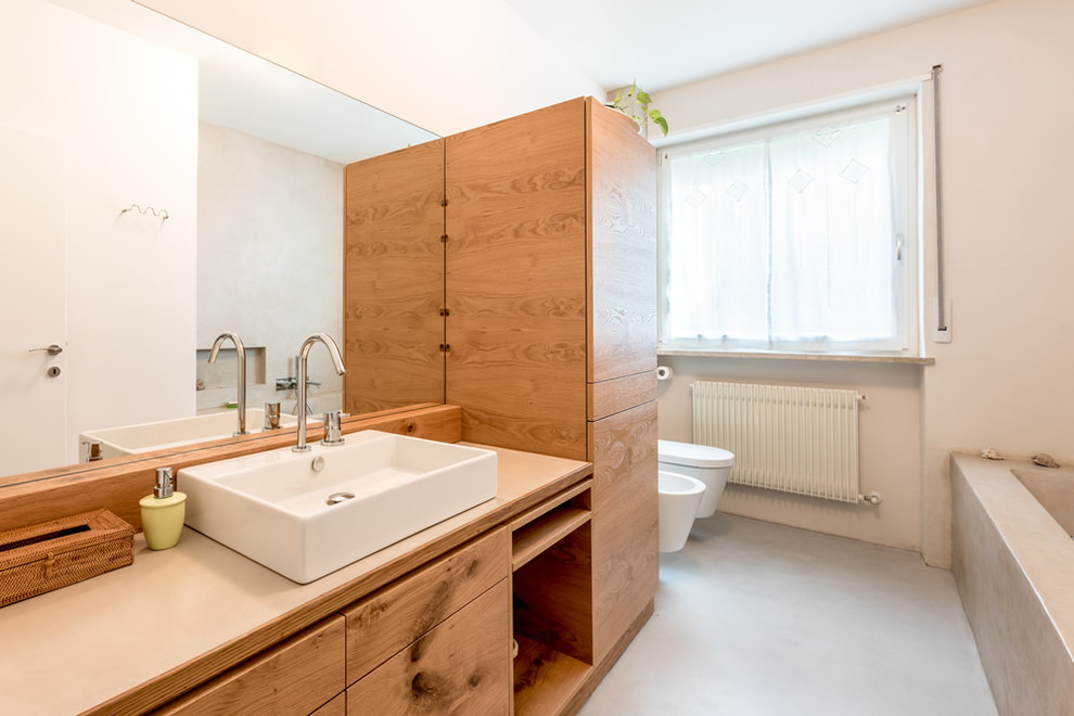 This is an example of a contemporary bathroom in Other with flat-panel cabinets, medium wood cabinets and wood benchtops.